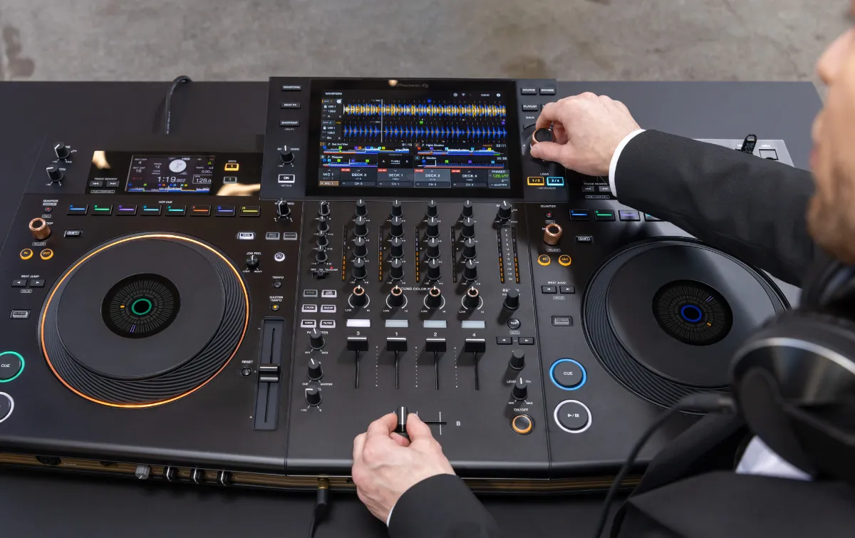 Vista superior de la parte central de la Opus Quad. Donde se ven los cuatro canales. Un Dj está manipulando el crossfader y la selección.